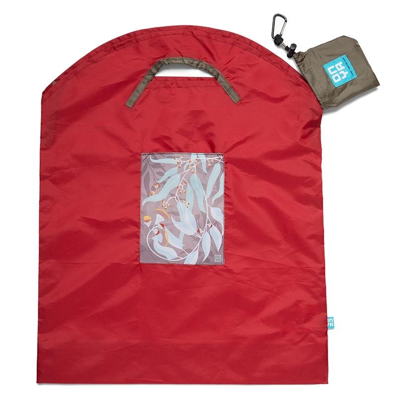 Large red reusable shopping bag by Onya with a brown carry pouch and black carabiner. The patch on the front of the bag has an image of dark vining leaves. Available at Green Distributors.
