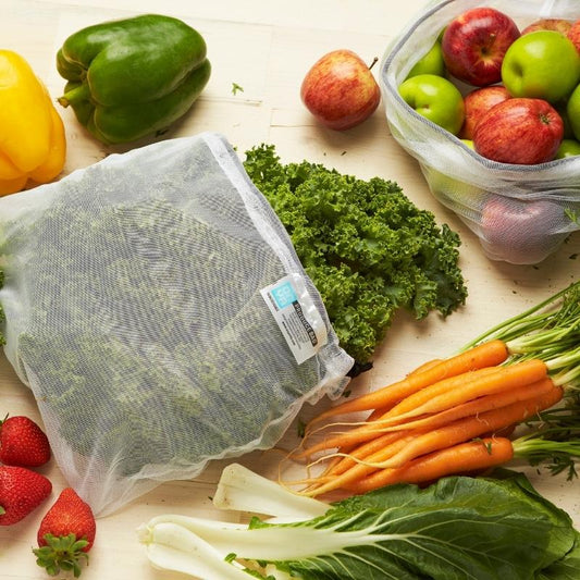 Onya reusable mesh produce bags with drawstrings all the way open. The bags are holding a variety of healthy fruits and vegetables. Available from Green Distributors.