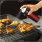 Tomato red Misto reusable gourmet oil misting bottle being used to add oil to pieces of chicken being cooked on a barbecue. Available at Green Distributors.