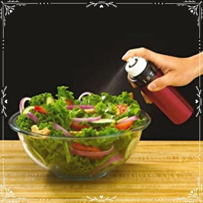 Tomato red Misto being used to spray oil on a large green salad of lettuce, tomatoes and red onions. Available at Green Distributors.
